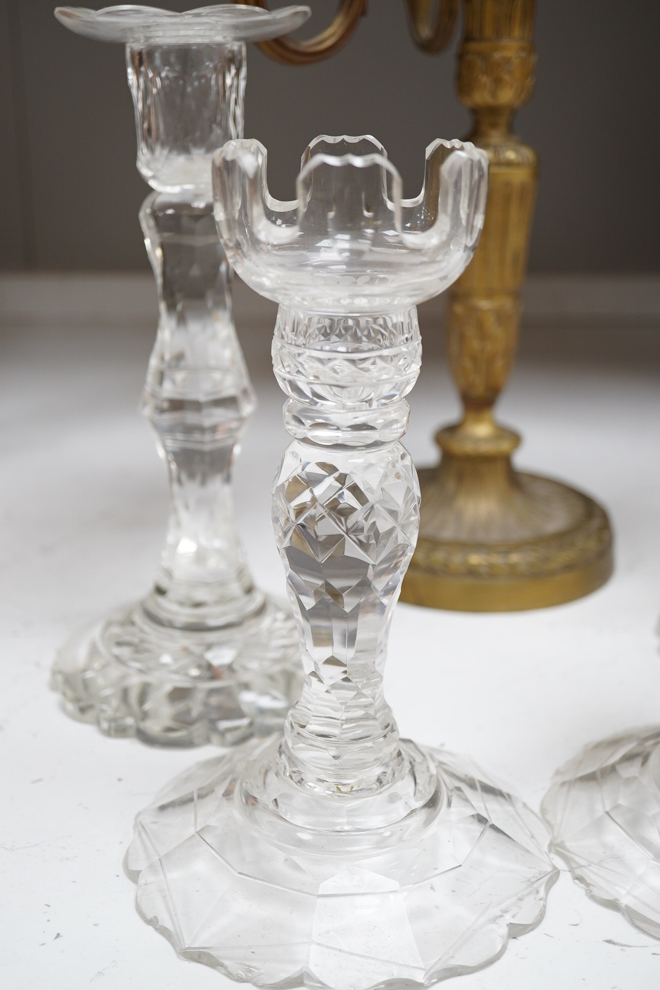 Two pairs of cut glass candlesticks and a gilt metal three branch candelabra, largest 44cm high. Condition - fair, some minor chipping